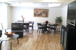 Lounge room with couch, television, table and chairs sitting area