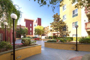 Castelar exterior, walking path, benches, trees and greenery, large light posts