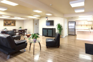 Kitchen, sitting area with couch and chairs and tables, television