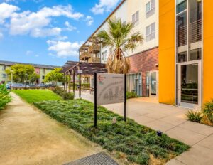 Crescent Cove exterior with signage and palm trees
