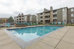 Fenced in community swimming pool, tanning chairs