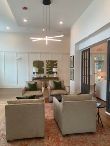 clubhouse lounge seating. contemporary space, neutral tones, sliding door leading to more seating