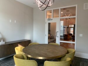 Executive Conference Room, 6 seats, large round table, contemporary chandelier, windows, view of business center lounge area.