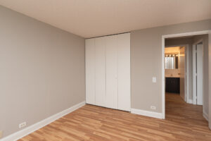 Unit Bedroom, Accordion style closet, wood floors, bathroom across from bedroom.