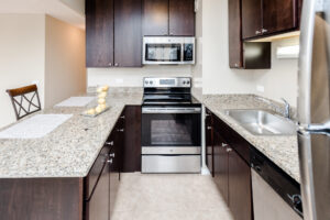 Unit Kitchen, Granite Countertops, Stainless Steel Appliances, Dark Brown Cabinetry, Tile Floor, Breakfast bar.