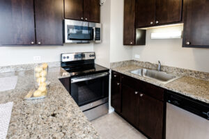 Granite Countertops, Stainless Steel Appliances, Tile Floor, Dark Brown Cabinetry
