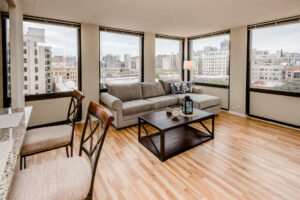 Unit Living Room, Photographed from breakfast bar, Large Windows along perimeter of living room, Grat sectional Couch