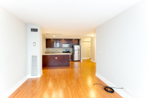 Unit Living room, Wood floors, kitchen attached to living room, open floor plan, stainless steel appliances in kitchen, dark brown cabinetry, apartment cable ready.