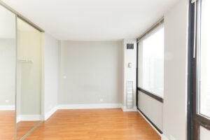 Unit Bedroom, mirrored sliding closet doors, 2 large windows with view of downtown in bedroom, wood floors.