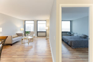Unit Hallway, View of living room and bedroom, wood floors, windows along farside wall.