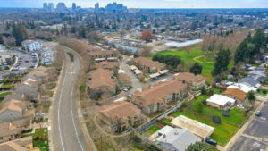 aerial exterior of rivers senior, photo taken in winter, park next to apartment complex, skyline in background.